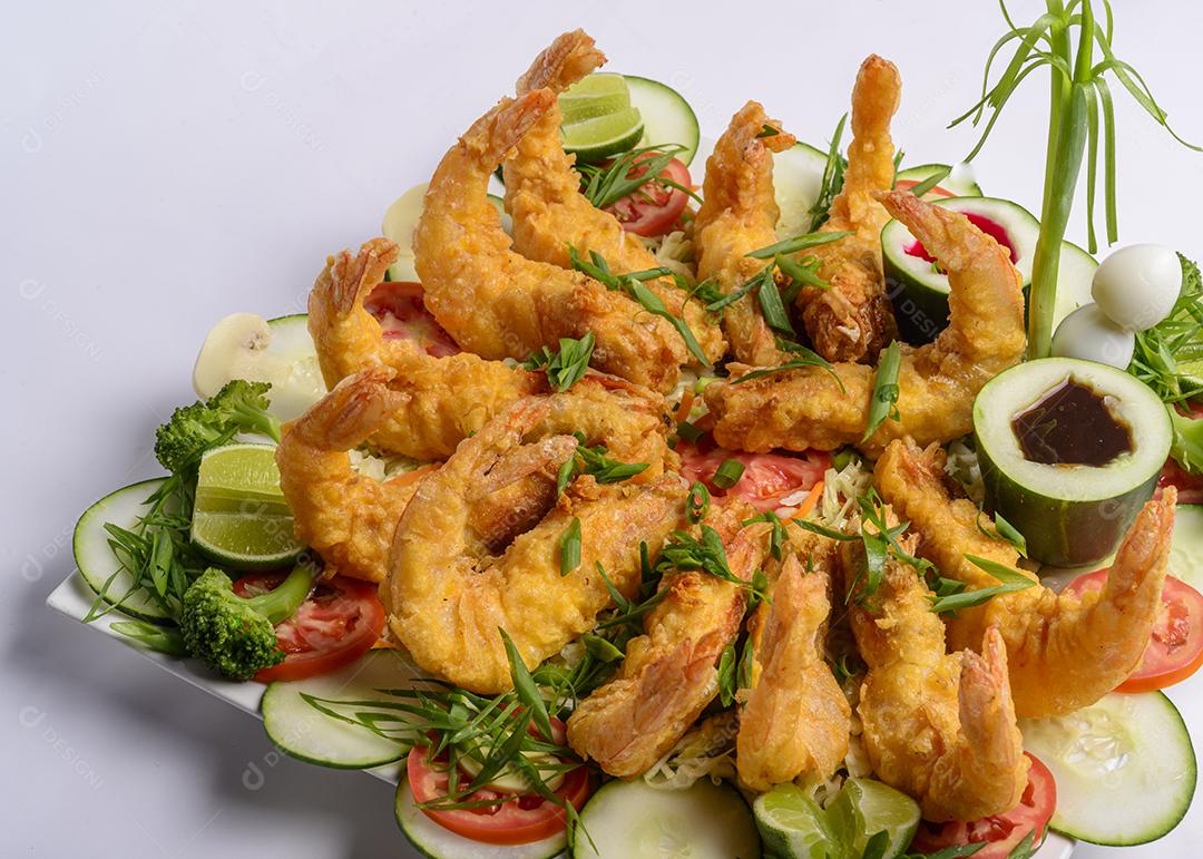 Comida oriental. Camarão crocante frito com legumes no fundo branco