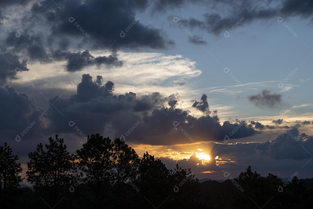 Pôr do sol no meio do céu nublado no Brasil