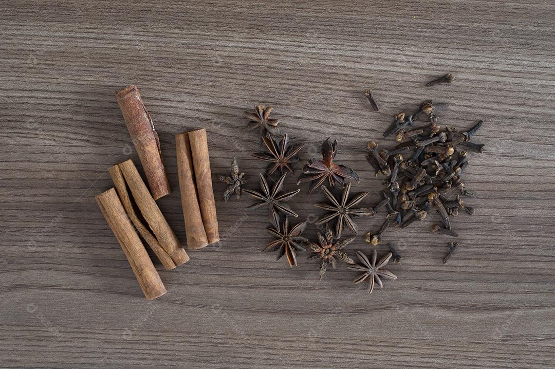 Paus de canela, anis estrelado e cravo sobre mesa de madeira