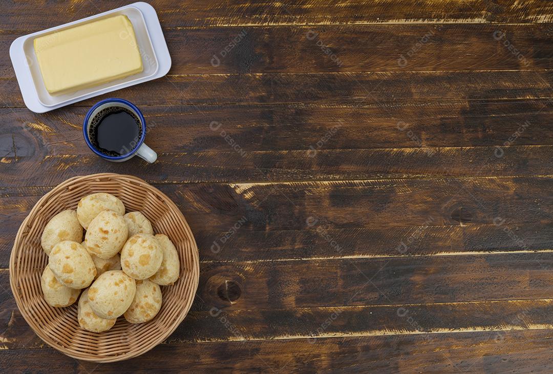 Pães de queijo brasileiro típicos em uma cesta, manteiga e café