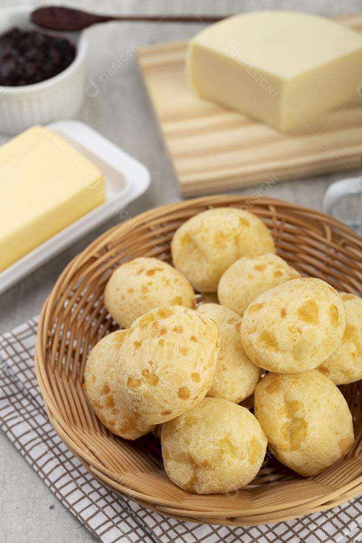 Pão de queijo típico brasileiro em uma cesta com manteiga, geleia