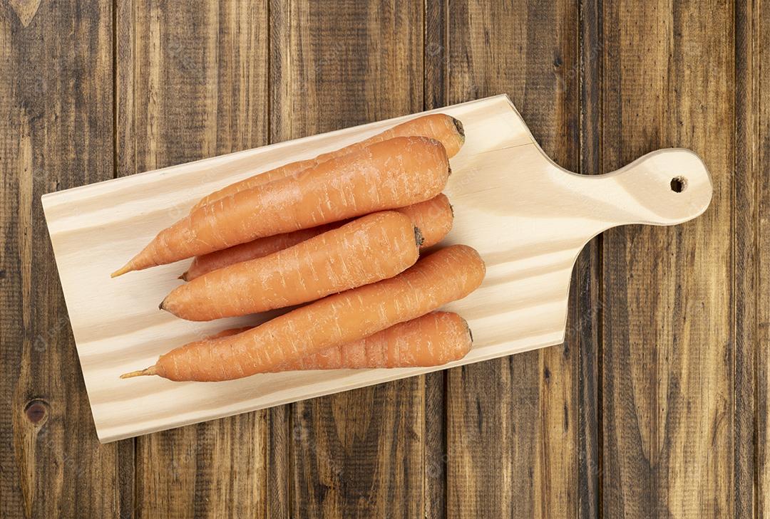 Cenouras sobre uma tábua em uma mesa de madeira