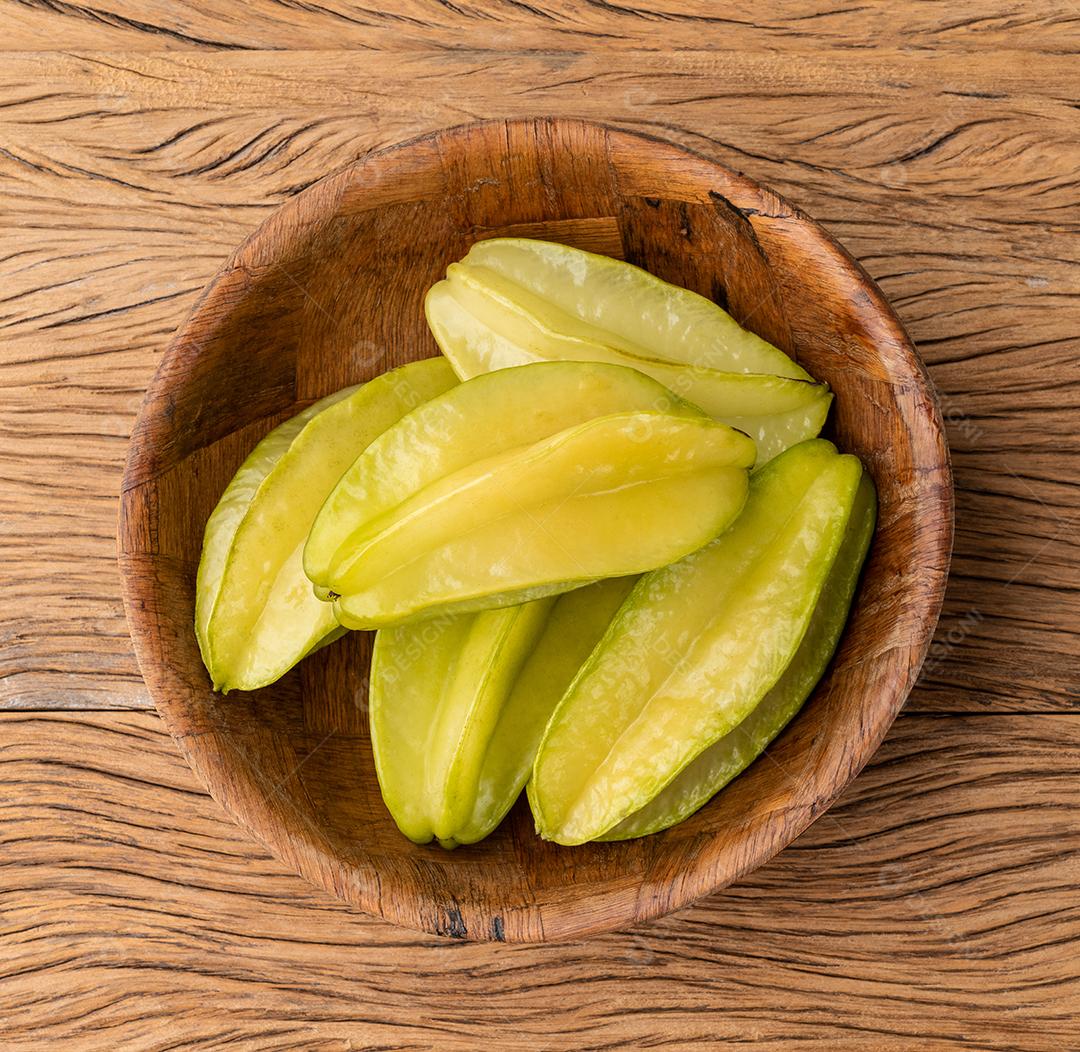 Carambolas em uma tigela sobre a mesa de madeira.