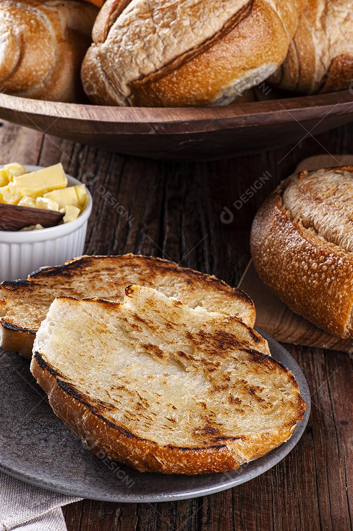 Pão francês cortado ao meio e tostado com manteiga