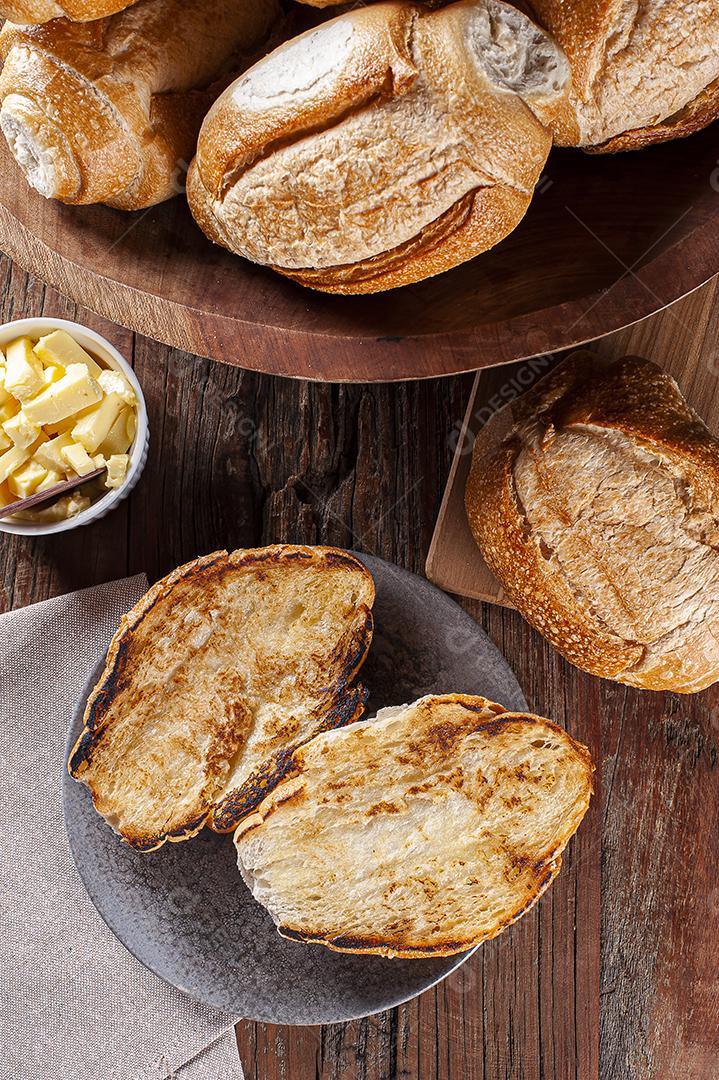 Pão francês cortado ao meio e tostado com manteiga