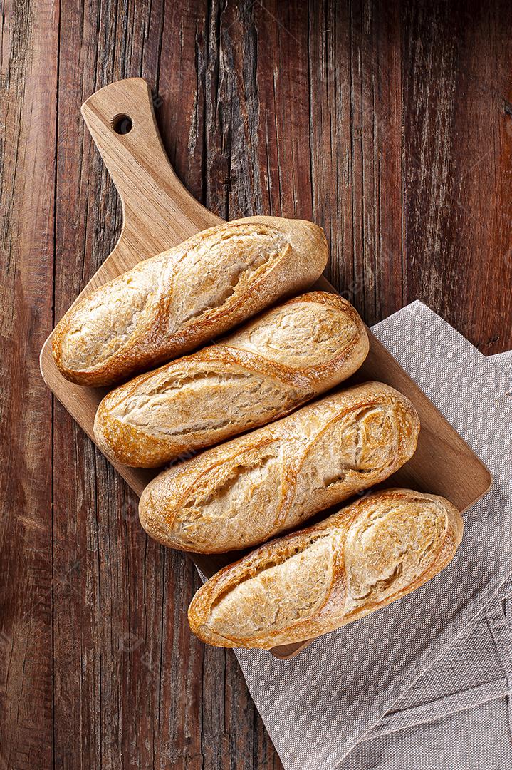 Baguetes francesas na placa de madeira.