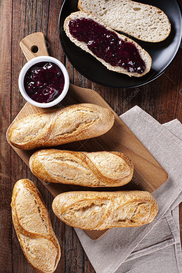 Baguetes francesas na placa de madeira. Acompanha geléia de frutas vermelhas