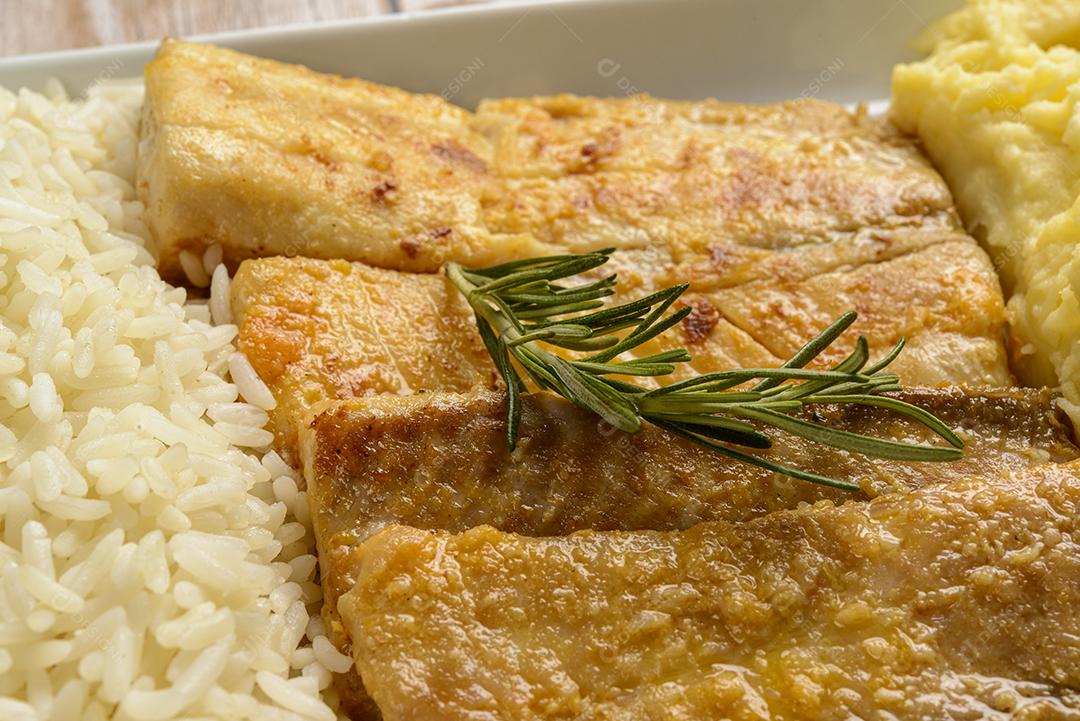 Peixe. Filé de tilápia com arroz branco e purê de batata.
