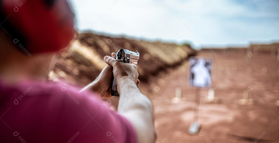 Visão detalhada atirador segurando arma treinando tiro tático, foco na pistola. Campo de tiro
