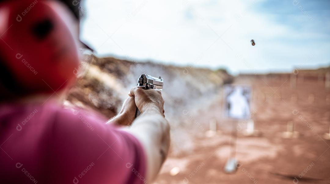 Visão detalhada atirador segurando arma treinando tiro tático, foco na pistola. Campo de tiro