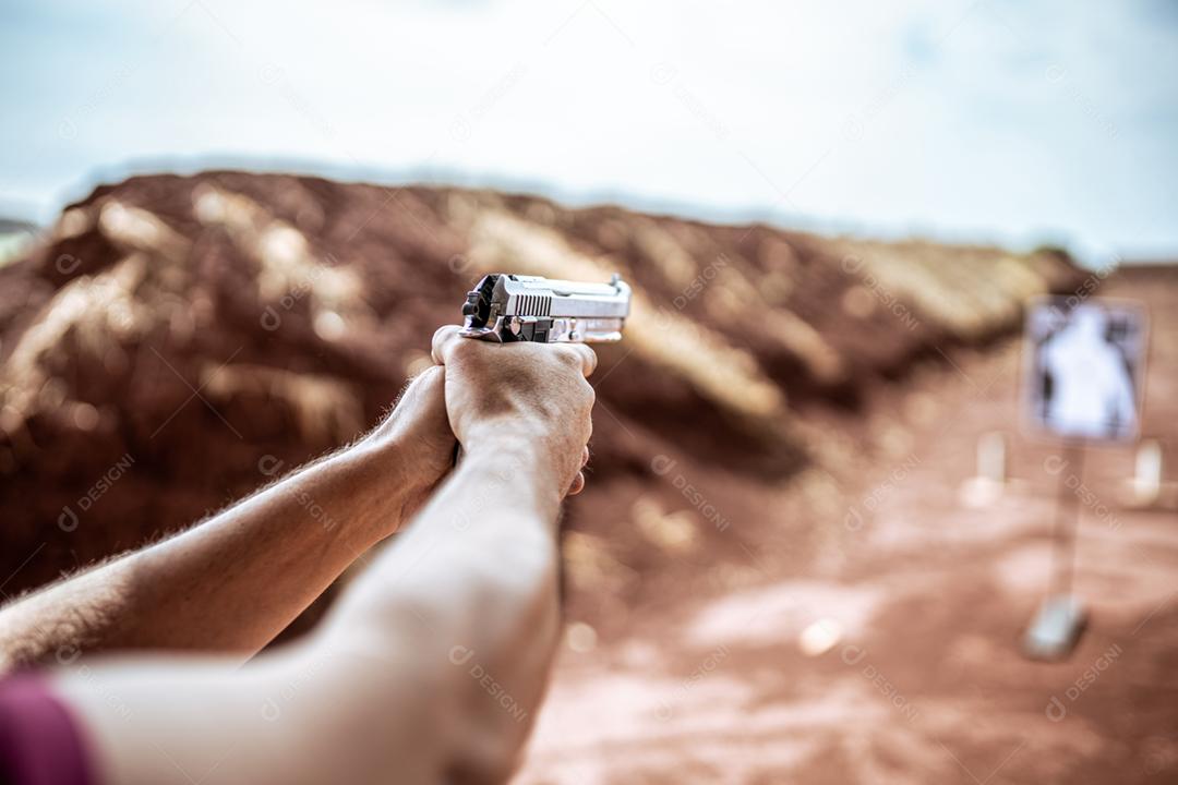 Visão detalhada atirador segurando arma treinando tiro tático, foco na pistola. Campo de tiro