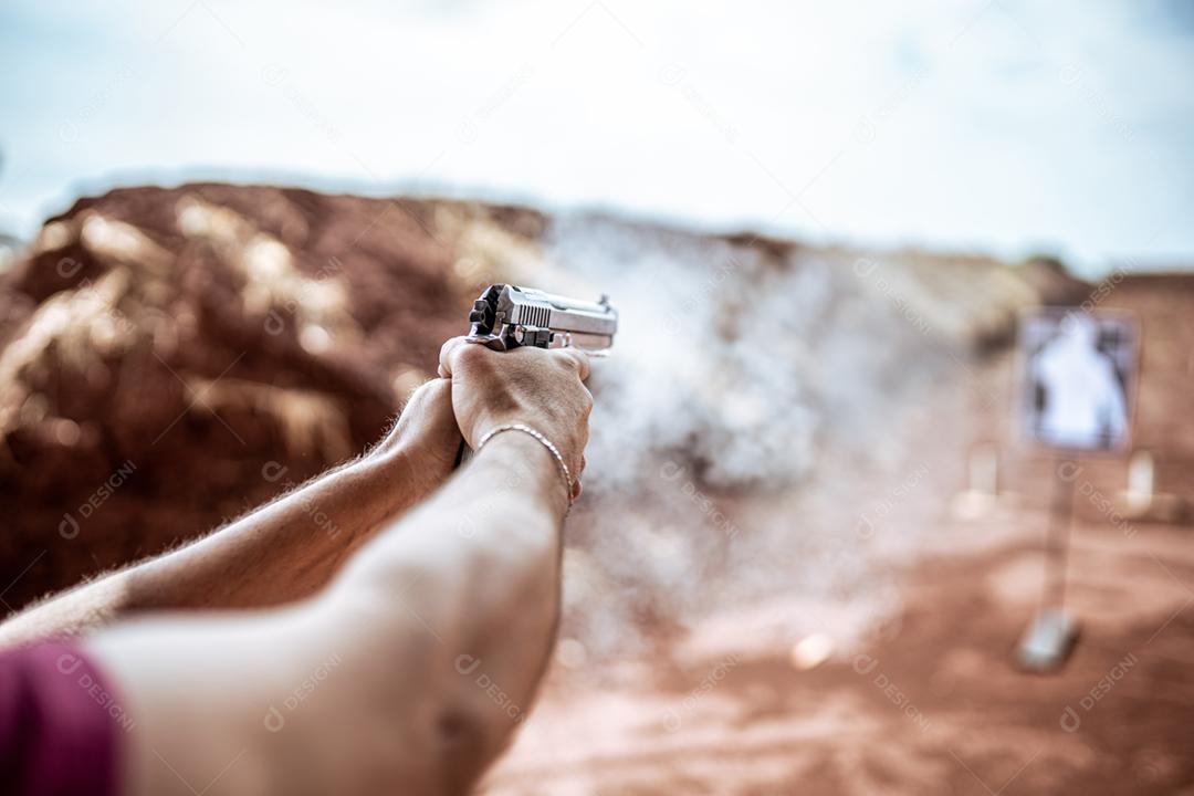 Visão detalhada atirador segurando arma treinando tiro tático, foco na pistola. Campo de tiro