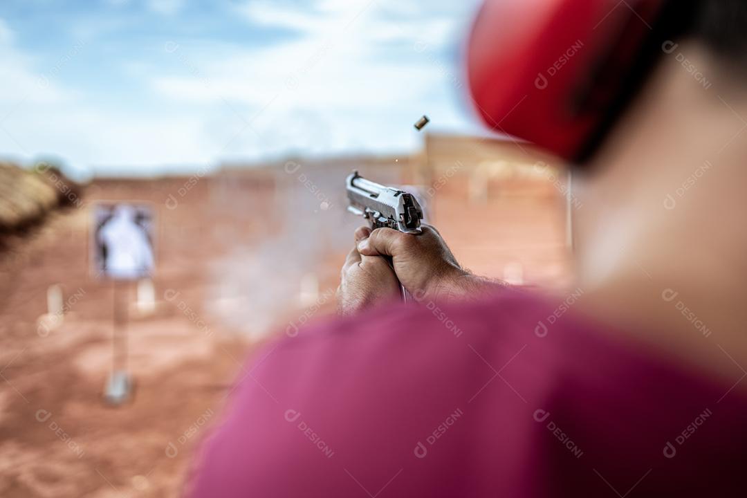 Visão detalhada atirador segurando arma treinando tiro tático, foco na pistola. Campo de tiro