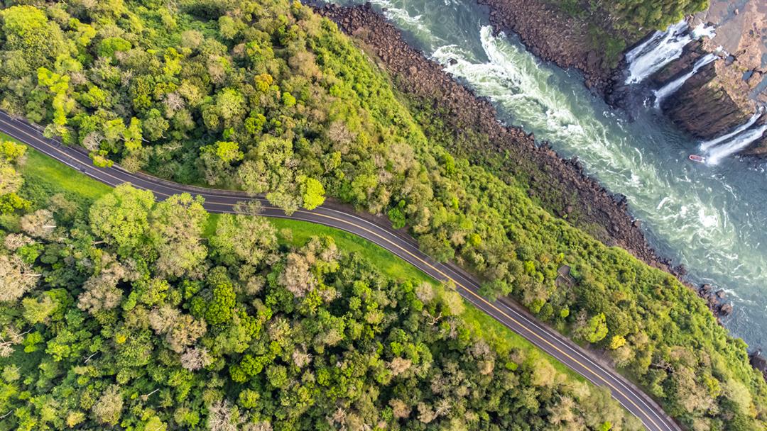 Vista aérea de uma rodovia ao lado de um rio no Parque Nacional do Iguaçu, Paraná, Brasil