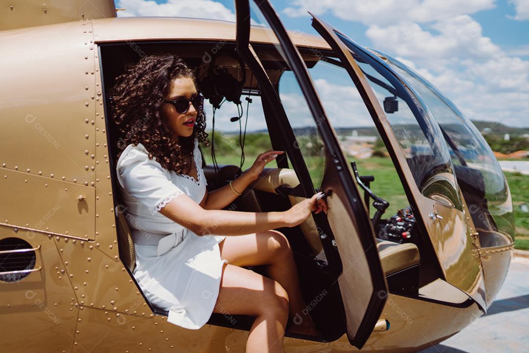 Bem sucedida inteligente elegante jovem Latina perto de helicóptero