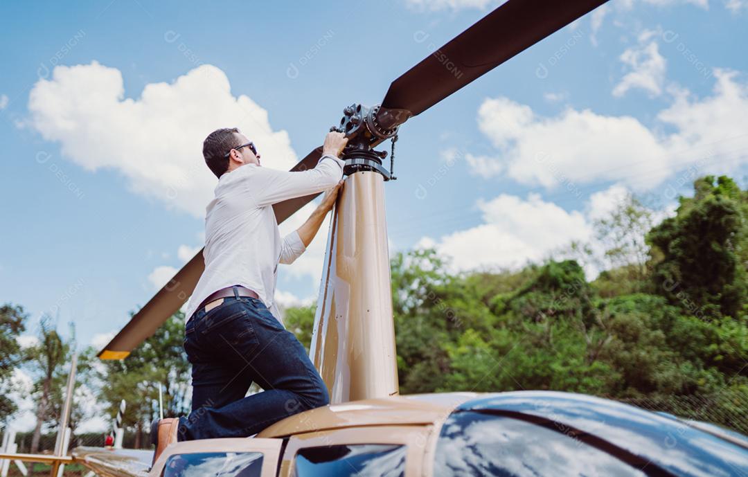 Mecânico masculino ou helicóptero examinando piloto. Inspeção pré-voo no heliponto