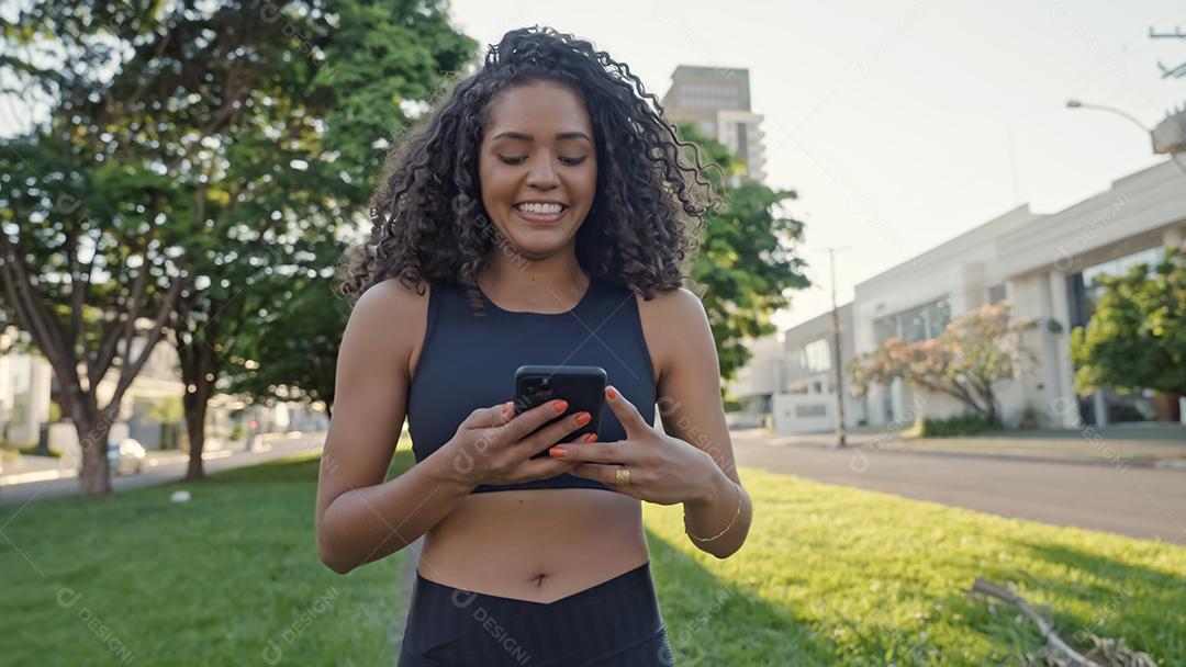 Mulher latina usando smartphone no parque. menina brasileira.