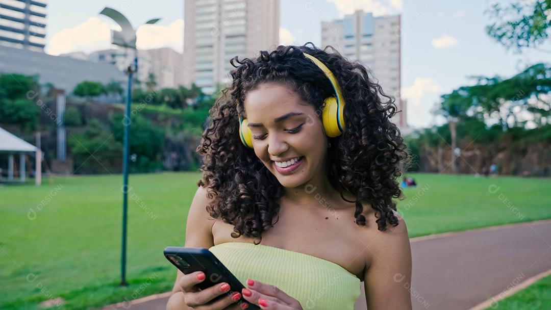 Mulher latina usando smartphone no parque. menina brasileira.