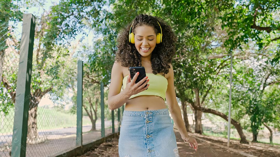 Mulher latina usando smartphone no parque. menina brasileira.