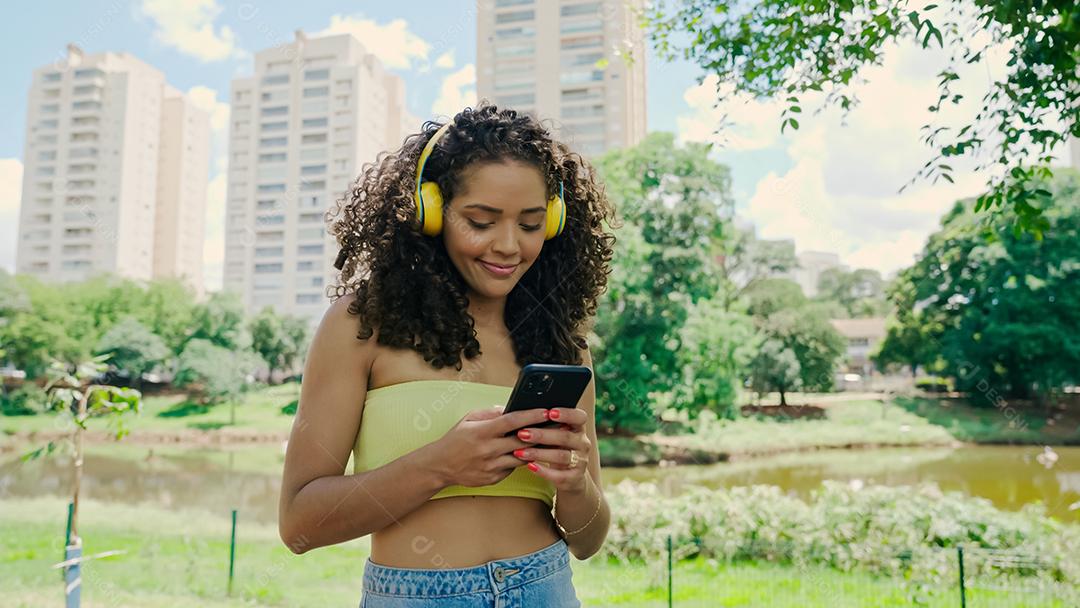 Latin woman using smartphone in the park. brazilian girl.