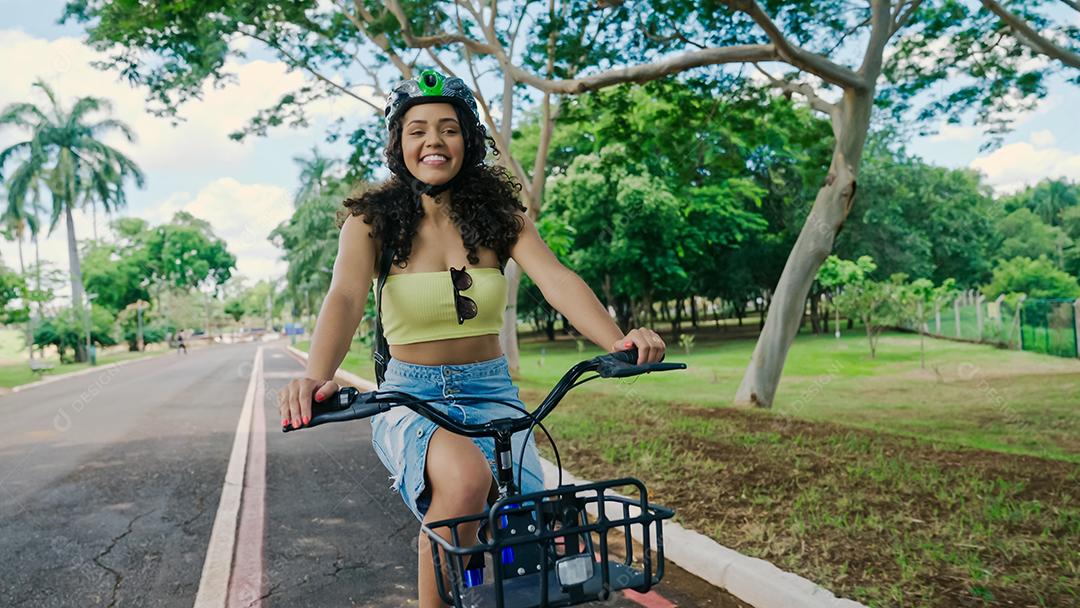 Jovem mulher latina em capacete protetor está andando de bicicleta