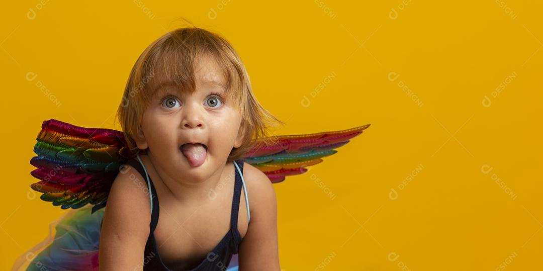 Cupido bonito com balão de forma de coração vermelho sobre fundo amarelo