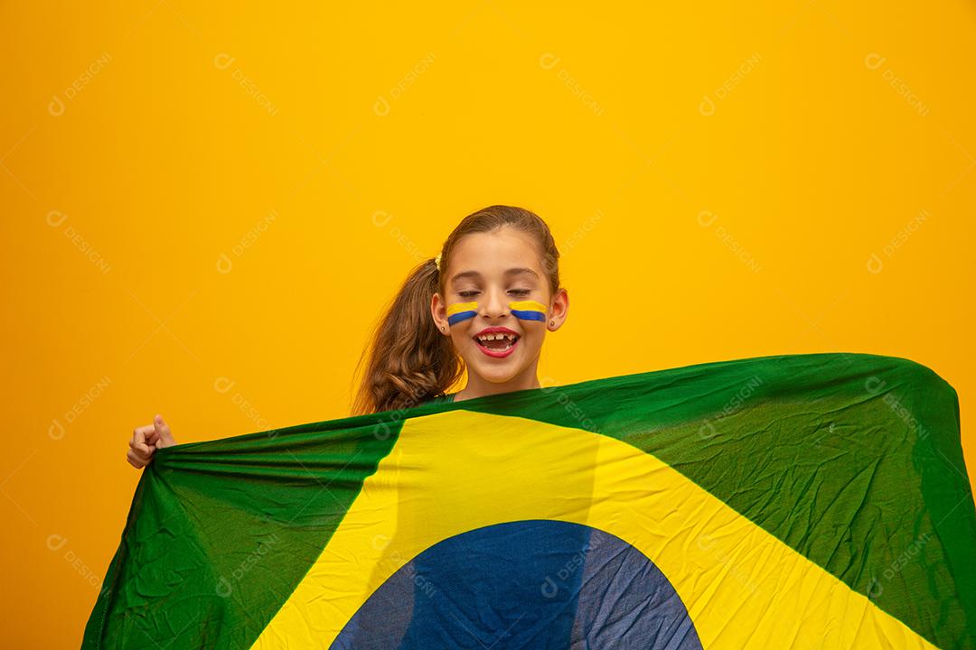 Torcedor de futebol, seleção brasileira. Copa do Mundo. Linda garotinha torcendo por seu time em fundo amarelo