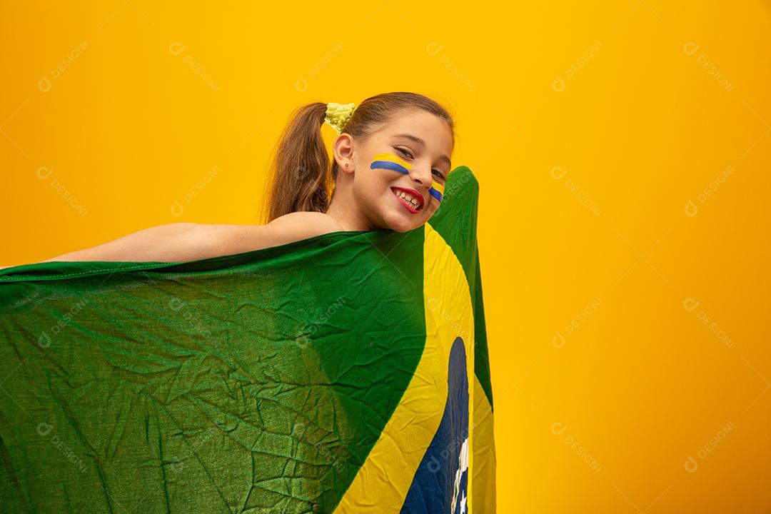 Torcedor de futebol, seleção brasileira. Copa do Mundo. Linda garotinha torcendo por seu time em fundo amarelo
