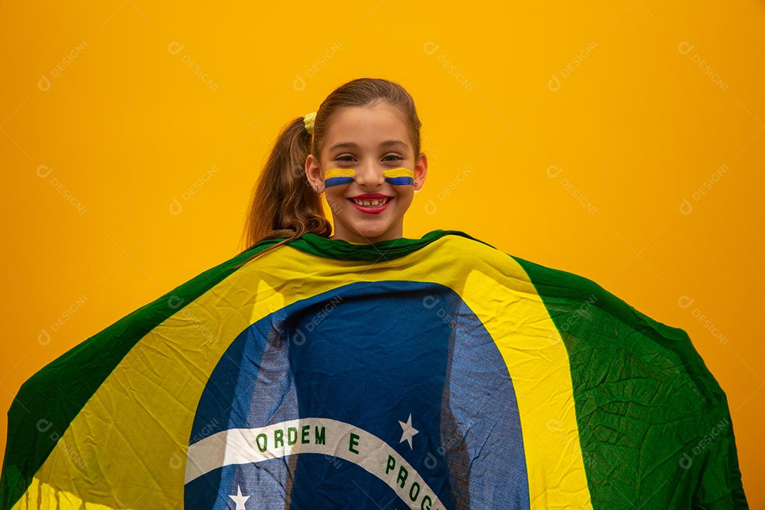 Torcedor de futebol, seleção brasileira. Copa do Mundo. Linda garotinha torcendo por seu time em fundo amarelo