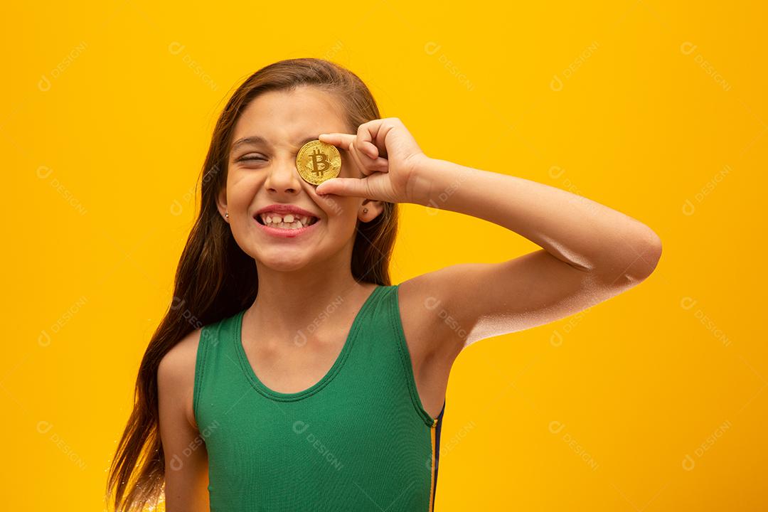 Criança segurando criptomoeda em metal. Moeda de ouro. Dourado