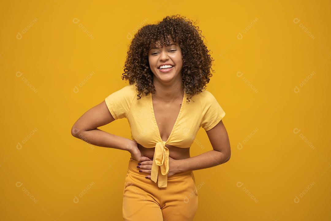 Mulher africana americana para trás com seu cabelo encaracolado em fundo amarelo. Rindo mulhe