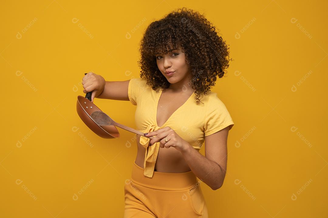 Utensílios de cozinha. Cozinhar a mulher na cozinha com frigideira e colher de pau. Dona de casa dançando.