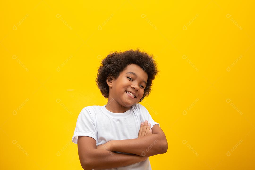 Menino afro-americano com cabelo black power em fundo amarelo. Garoto moreno sorridente