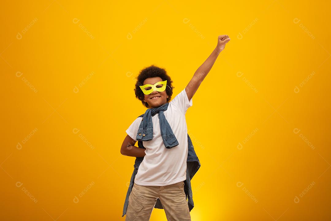 Retrato de um menino jovem e mestiço vestido como um super-herói. Bebê preto em traje de super-herói