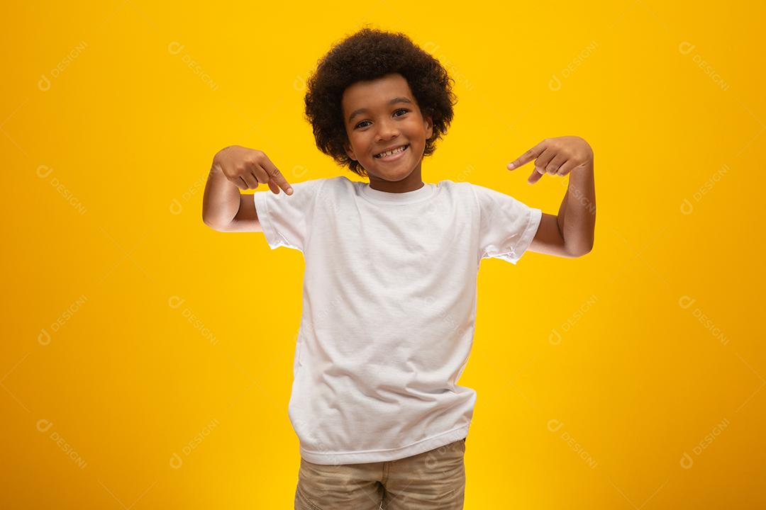 Menino afro-americano com cabelo black power em fundo amarelo. Garoto moreno sorridente