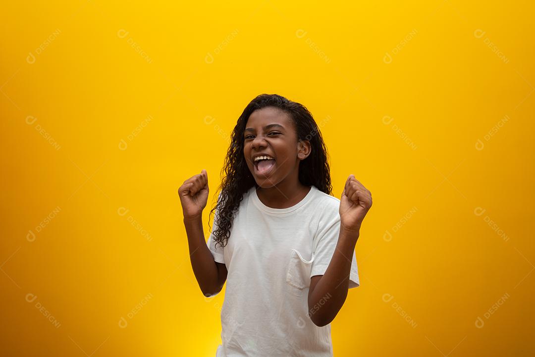 Menina afro-americana feliz no fundo amarelo do estúdio, copie o espaço. Retrato de uma linda criança se divertindo