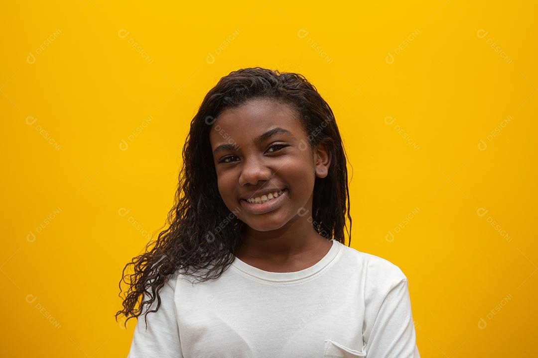 Garota afro-americana com cabelo encaracolado em fundo amarelo. Garoto negro sorridente