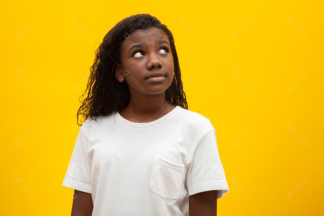 Crianças pensativas sobre fundo amarelo.