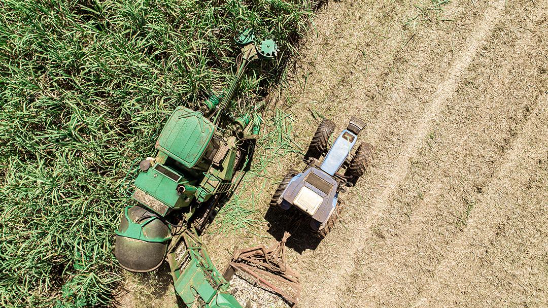 Colheita de cana-de-açúcar em dia ensolarado no Brasil. Vista aérea.