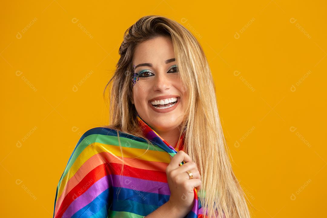 Mulher jovem de cabelo loiro fantasiado curtindo a festa de carnaval cobrindo com camiseta do orgulho lgbt