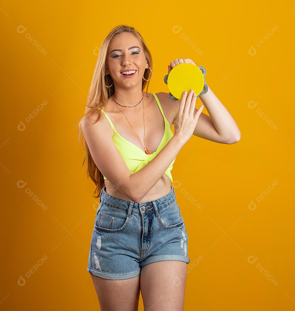 Blonde woman with long hair holding a toy tambourine in her hands