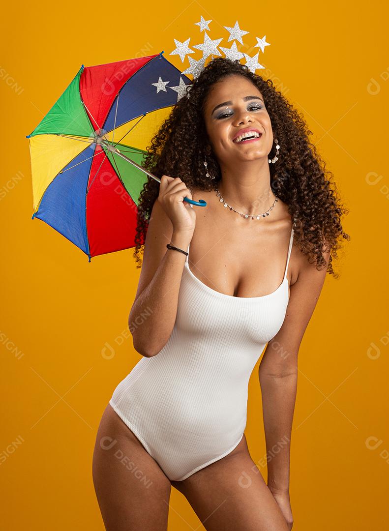 Jovem mulher de cabelo encaracolado celebrando a festa do carnaval brasileiro