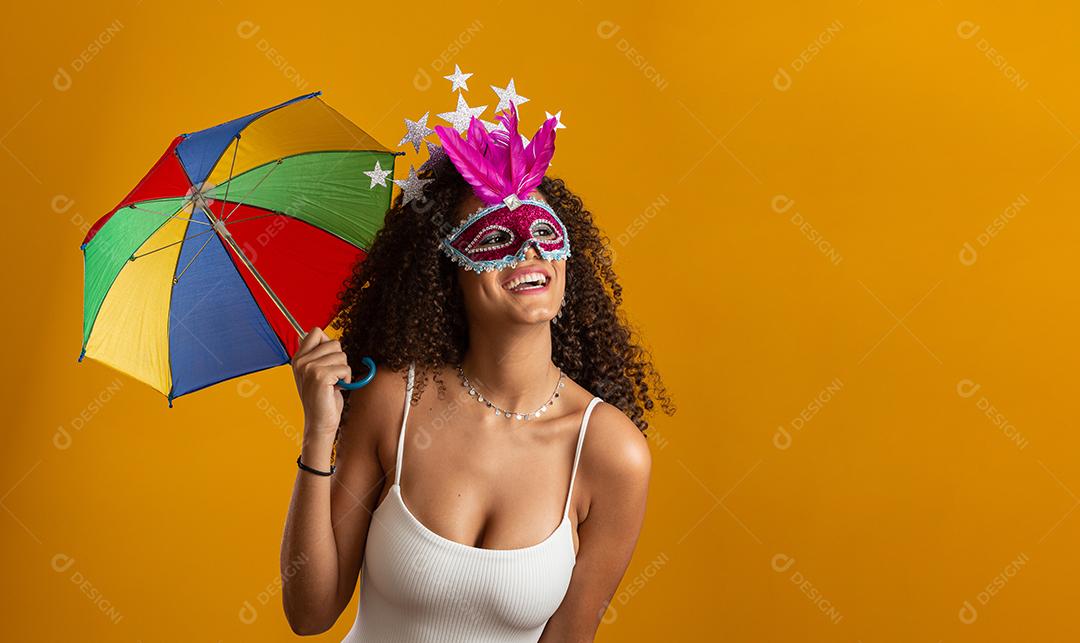 Jovem mulher de cabelo encaracolado celebrando a festa do carnaval brasileiro