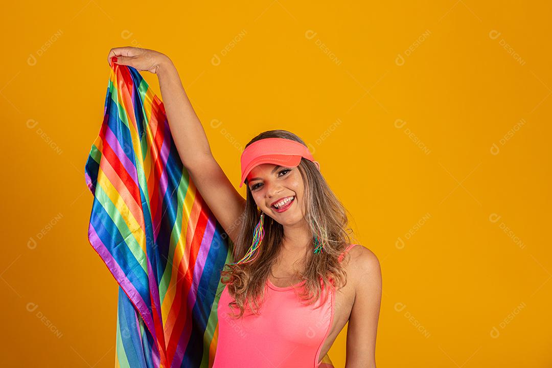 Mulher jovem de cabelo loiro cobrindo com a bandeira do orgulho lgbt. Sozinho. Um. Mantendo o punho erguido