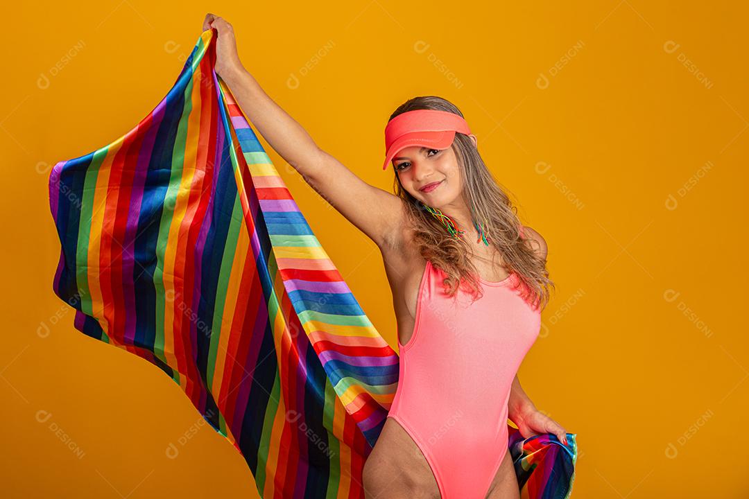Mulher jovem de cabelo loiro cobrindo com a bandeira do orgulho lgbt. Sozinho. Um. Mantendo o punho erguido