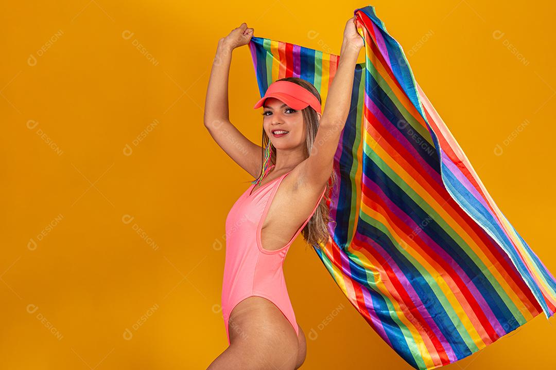 Mulher jovem de cabelo loiro cobrindo com a bandeira do orgulho lgbt. Sozinho. Um. Mantendo o punho erguido