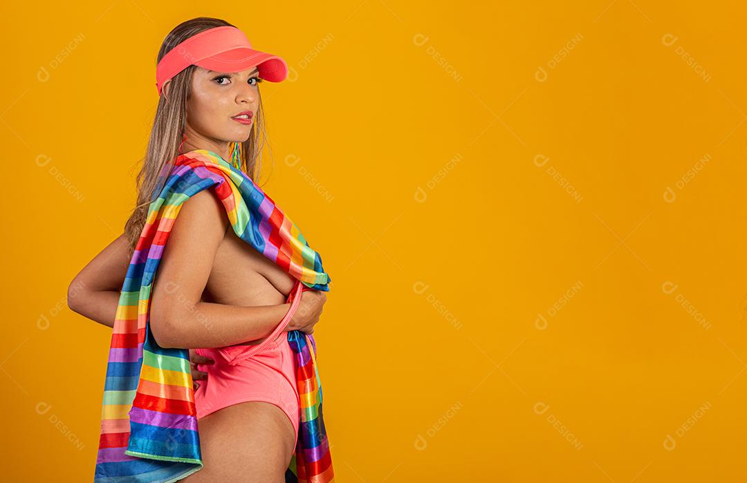 Mulher jovem de cabelo loiro cobrindo com a bandeira do orgulho lgbt. Sozinho. Um. Mantendo o punho erguido