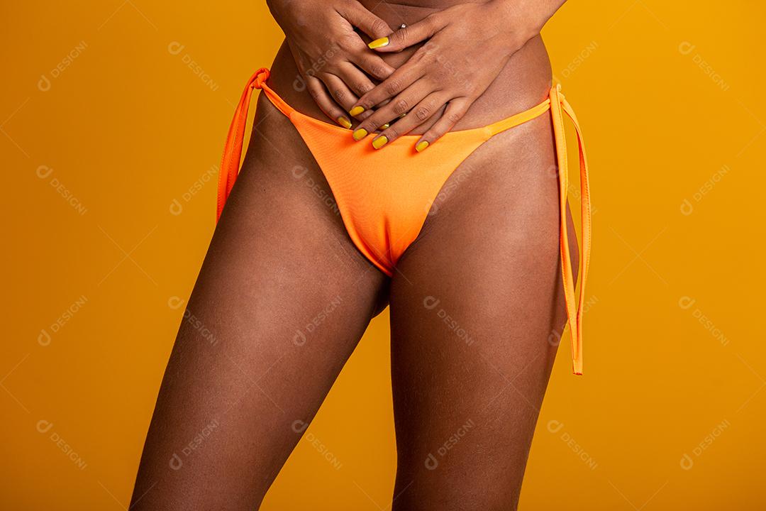 Garota de cabelo encaracolado atraente em um biquíni laranja, chapéu, boca aberta emocionalmente