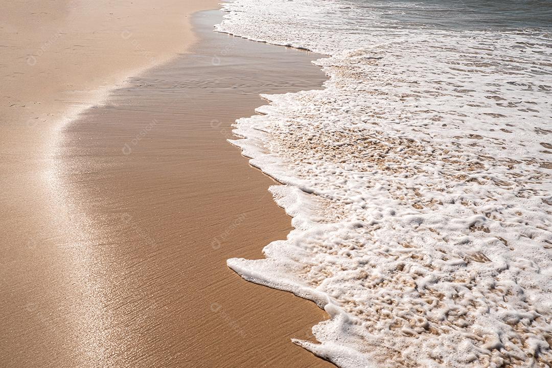 Ondas suaves com espuma do oceano no fundo da praia