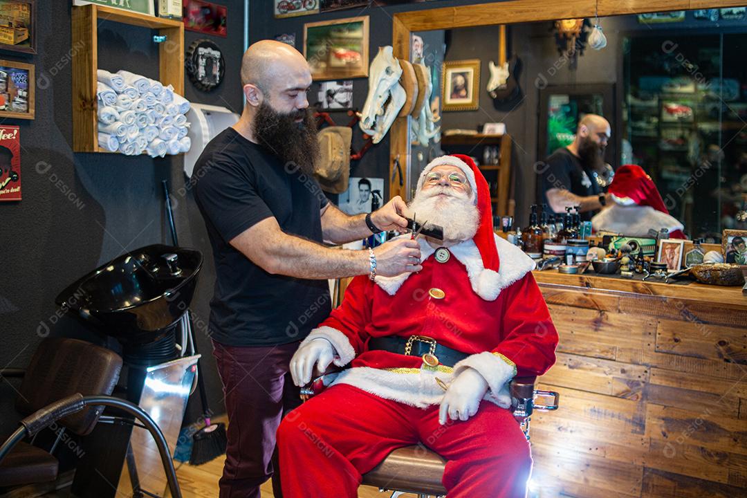 Papai Noel se barbeando na barbearia. Olhando no espelho